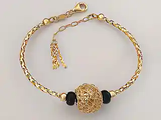 Lovrin Złota bransoletka 585 bangle z ażurową kulką czarne kamienie
