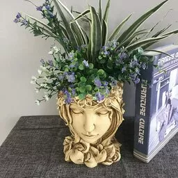 Złoty wazon na kwiaty w kształcie kobiecej głowy