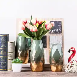 Ceramiczny wazon ze złotym wykończeniem idealnie prezentuje się w otoczeniu współczesnych ozdób i dekoracji Ceramiczny wazon ze złotym wykończeniem idealnie prezentuje się w otoczeniu współczesnych ozdób i dekoracji
